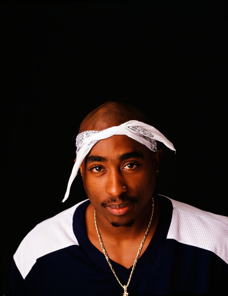 a man with a bandana on his head wearing a necklace and a chain around his neck