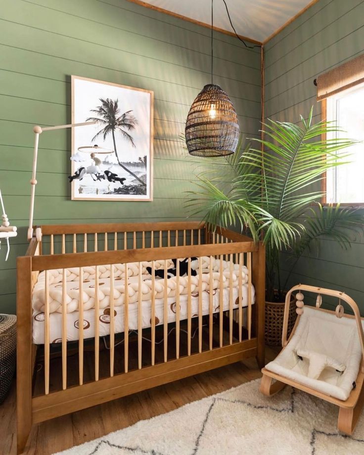 a baby's room with a crib, rocking chair and potted plant