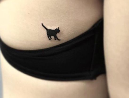 a black cat tattoo on the side of a woman's stomach