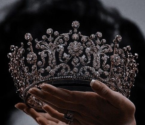 a woman holding a tiara in her hands