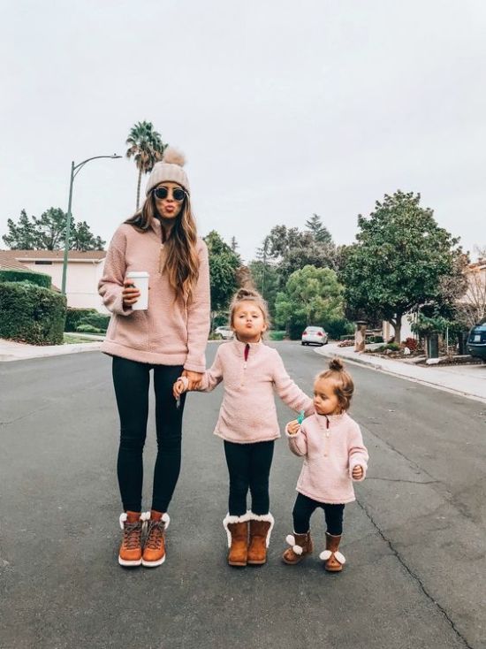 a woman and two children are walking down the street with their arms around each other