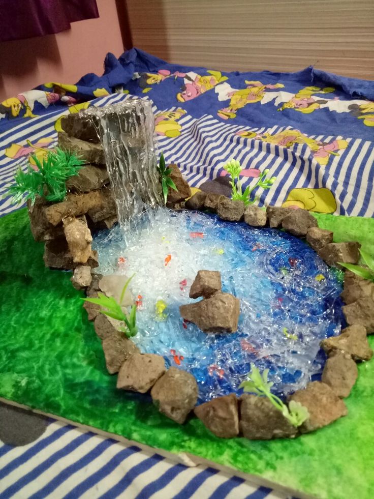 a cake made to look like a pond with rocks and water flowing from the top