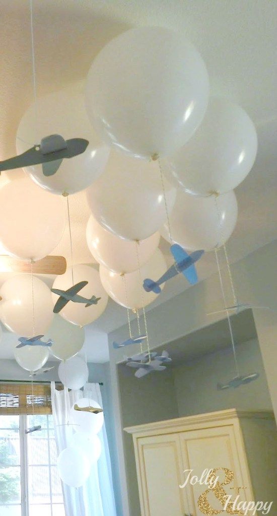 white balloons are hanging from the ceiling in a room