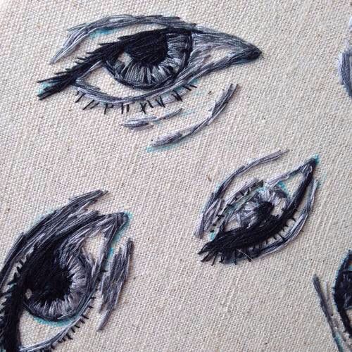 an eye is drawn on the fabric with black and white ink, while other drawings are drawn