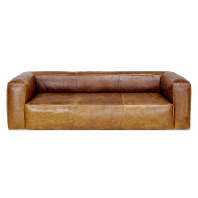 a brown leather couch sitting on top of a white floor