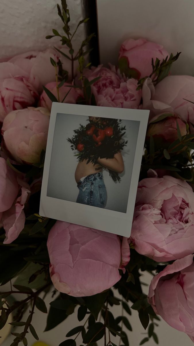 a bouquet of pink flowers with a polaroid frame