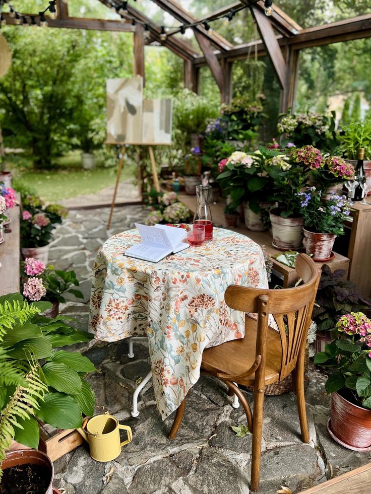 a table and chairs in a garden with potted plants on the ground next to it