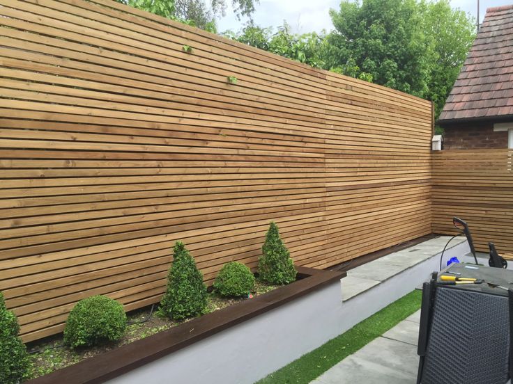 a wooden fence next to a lawn with grass