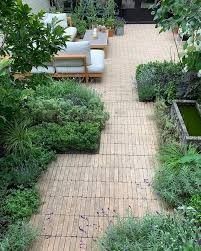 an outdoor garden with lots of plants and furniture