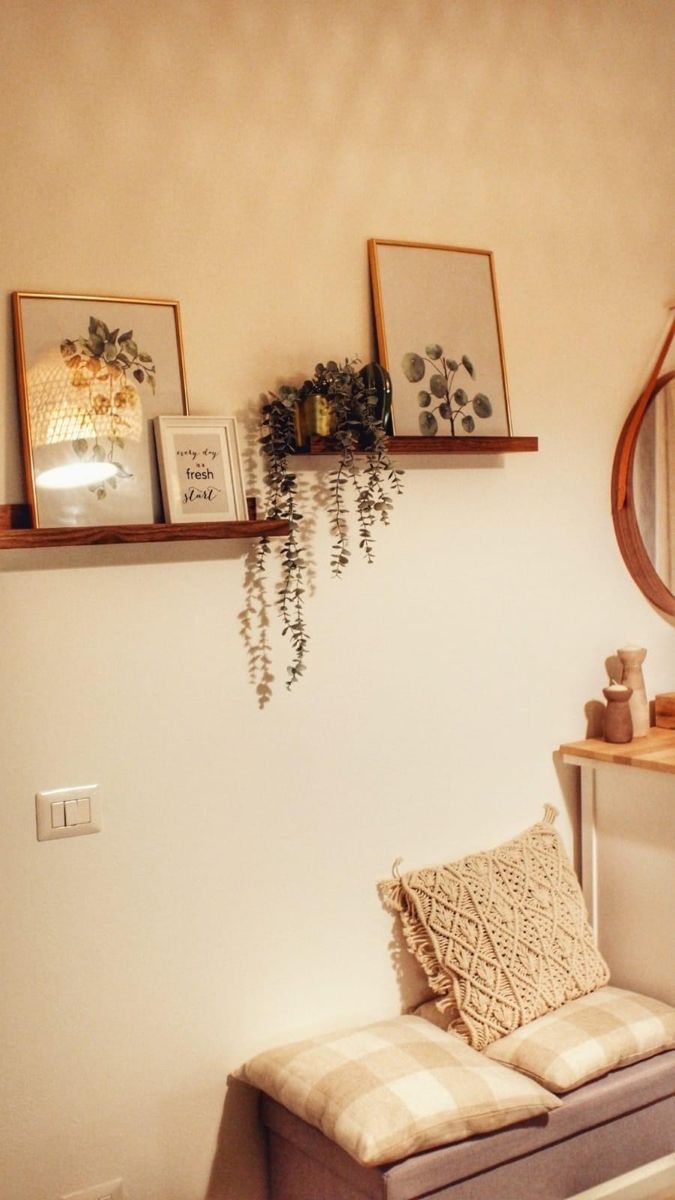 a living room filled with furniture and pictures hanging on the wall above a window sill