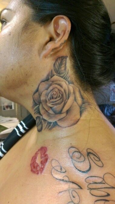 a woman with a rose tattoo on her neck and behind her ear is the words love