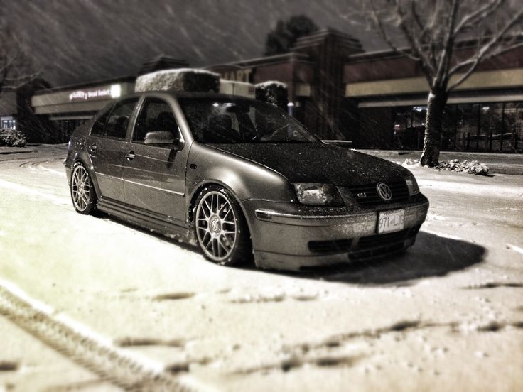 the car is parked on the snowy street