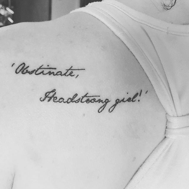 the back of a woman's shoulder with an inscription on it