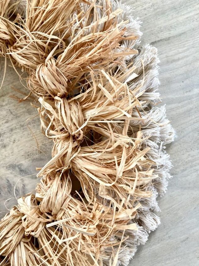 a close up of a wreath made out of straw on top of a wooden table