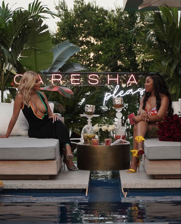 two women sitting on couches in front of a sign that says careesha