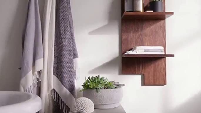 a bathroom with a toilet, sink and shelves on the wall next to each other