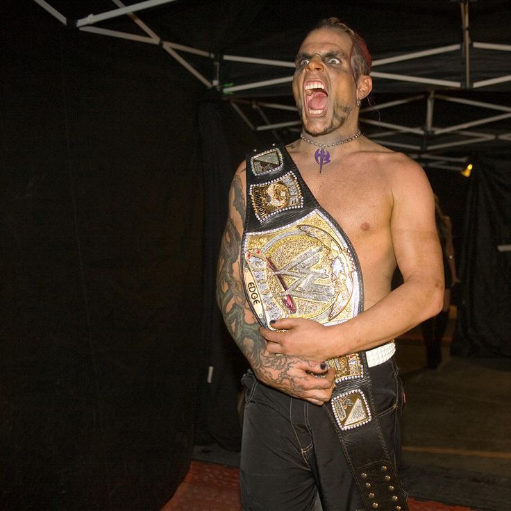 a man with his mouth open holding a wrestling belt