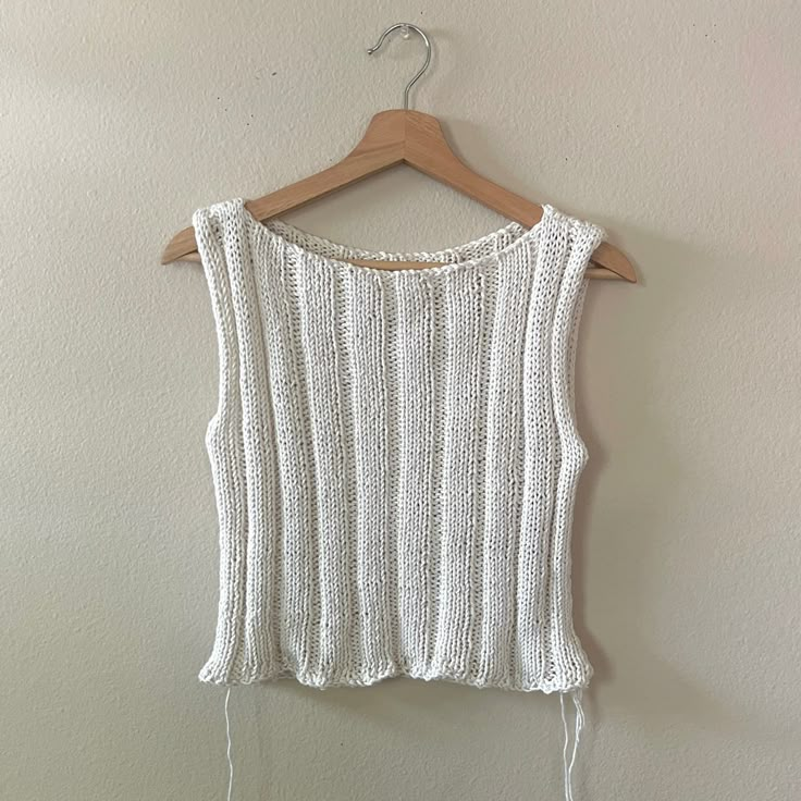 a white top hanging on a wooden hanger