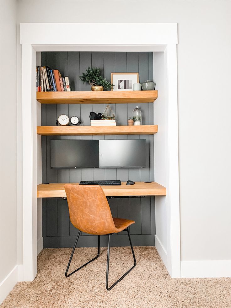 a desk and chair in a room with shelves on the wall above it, along with bookshelves