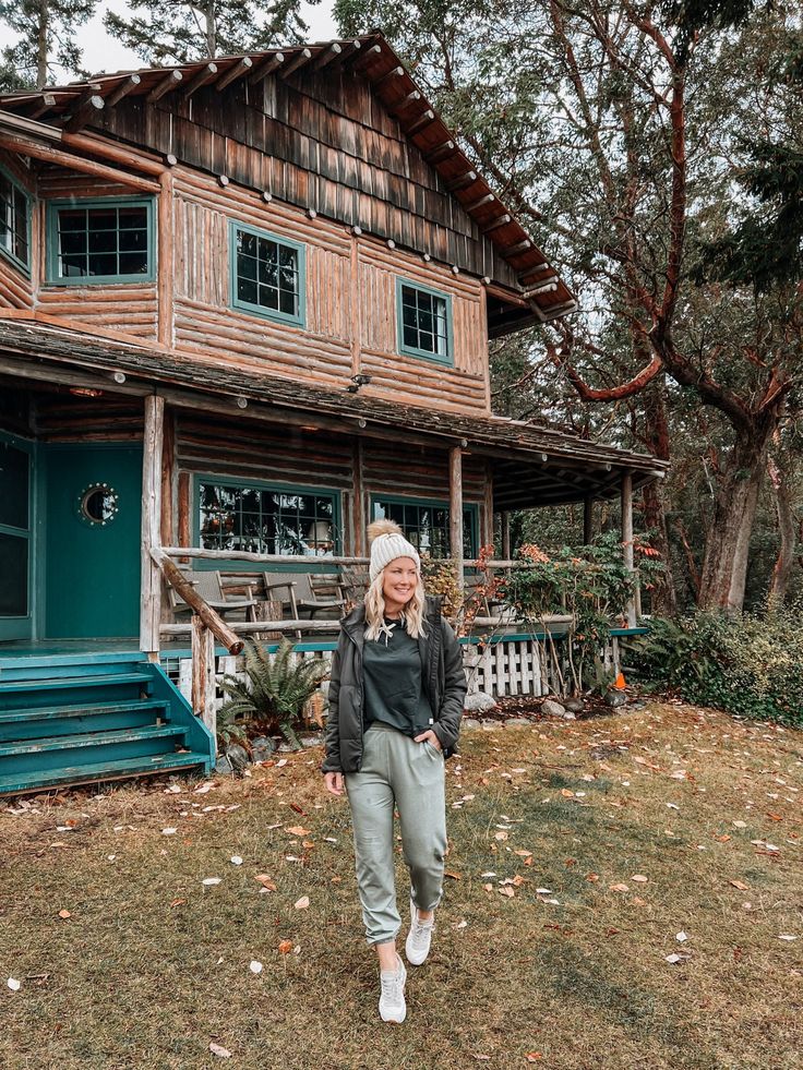 a woman standing in front of a wooden house