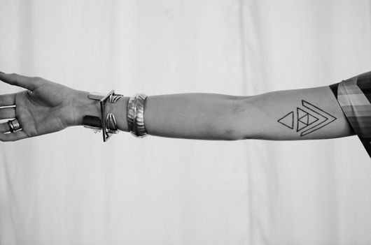 a person's arm with tattoos on it