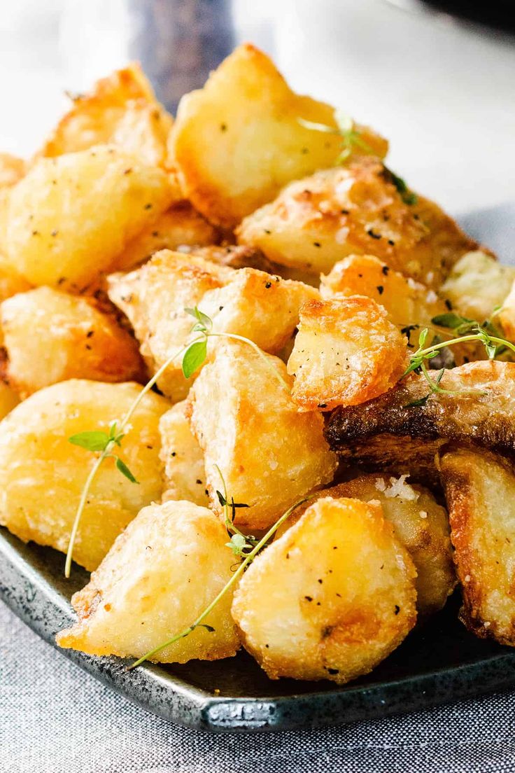 a close up of a plate of food with potatoes and herbs on the side,