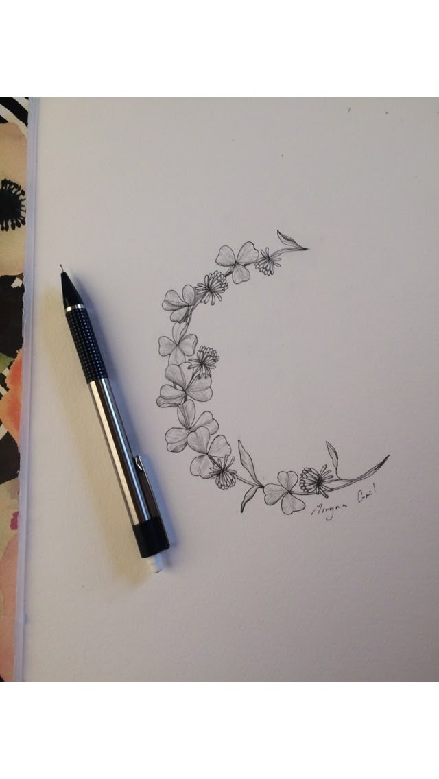 a pen and some flowers on top of a sheet of paper next to a drawing