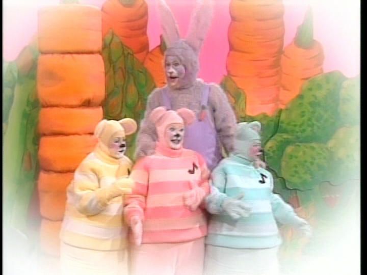 three people dressed in bunny costumes standing next to each other with carrots behind them