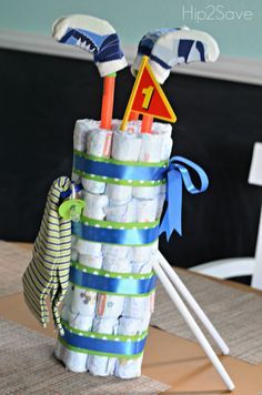 a stack of diapers and golf tees on top of a table with a blue ribbon