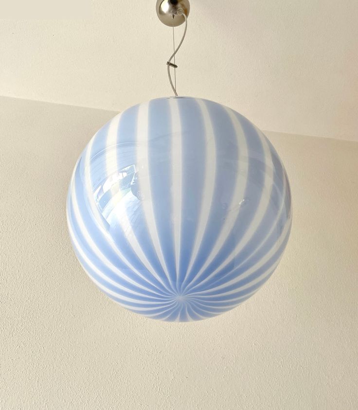 a blue and white striped light fixture hanging from a ceiling in a home or office