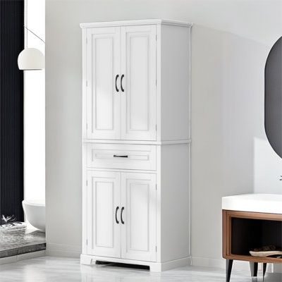 a white cabinet in a bathroom next to a sink