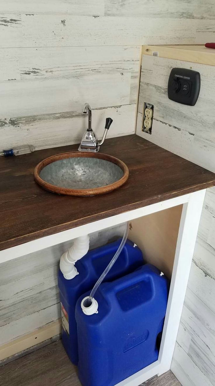 a bathroom sink with a blue container underneath it