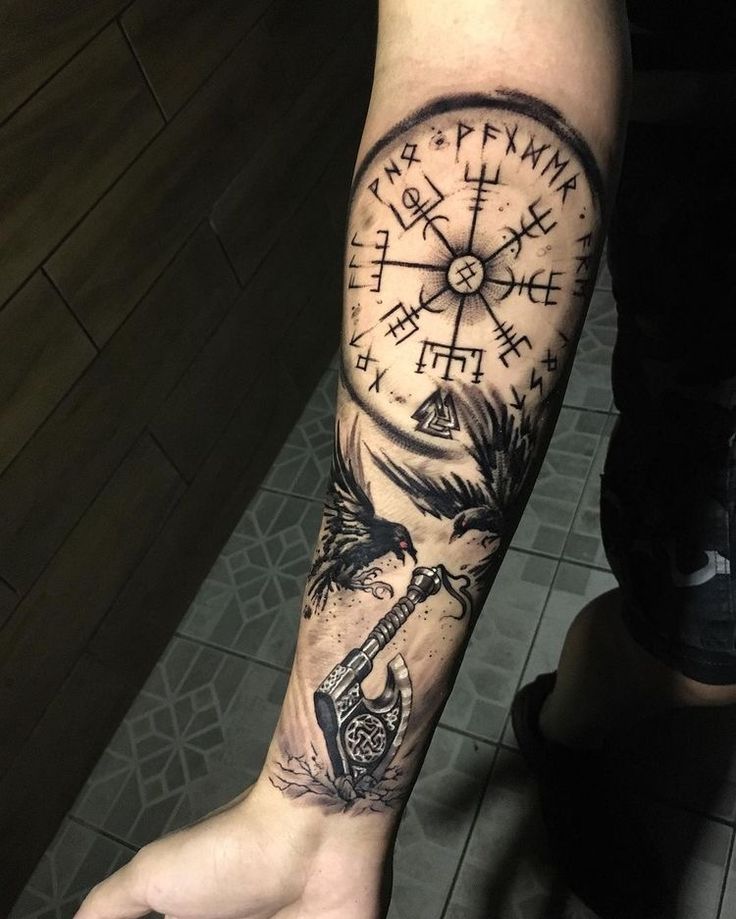 a man with a compass tattoo on his arm