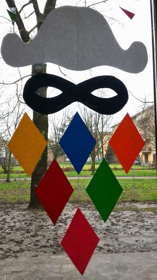 a window decorated with different colored squares and a mask hanging from it's side