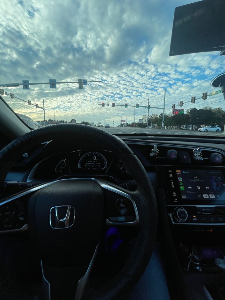 the interior of a car with an electronic display and steering wheel view through the windshield