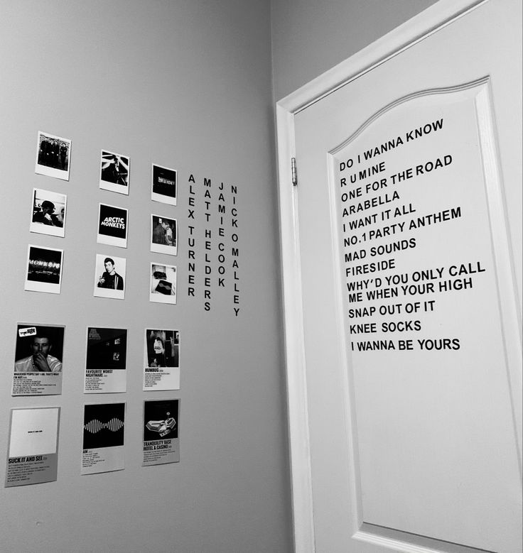 black and white photograph of an open door with many pictures on the wall next to it