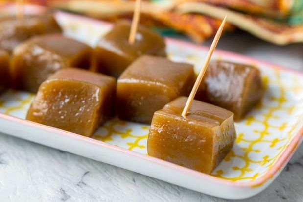 several pieces of caramel on a plate with toothpicks