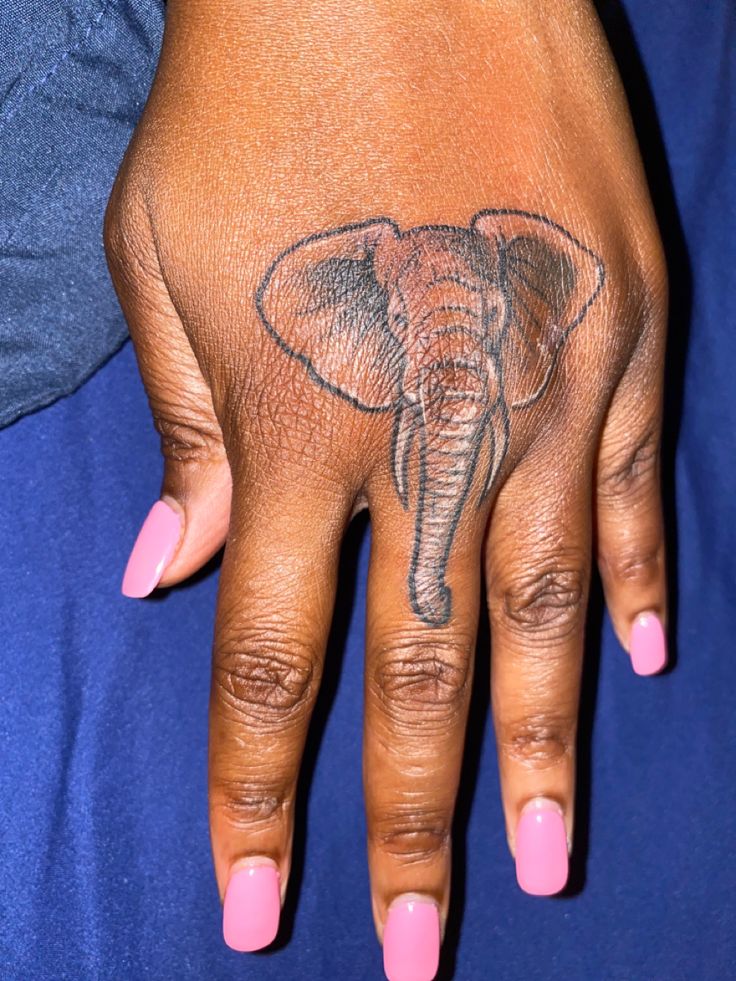 a woman's hand with an elephant tattoo on it