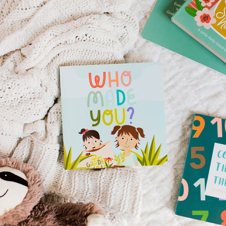 children's books are laying on a bed next to a teddy bear and stuffed animal