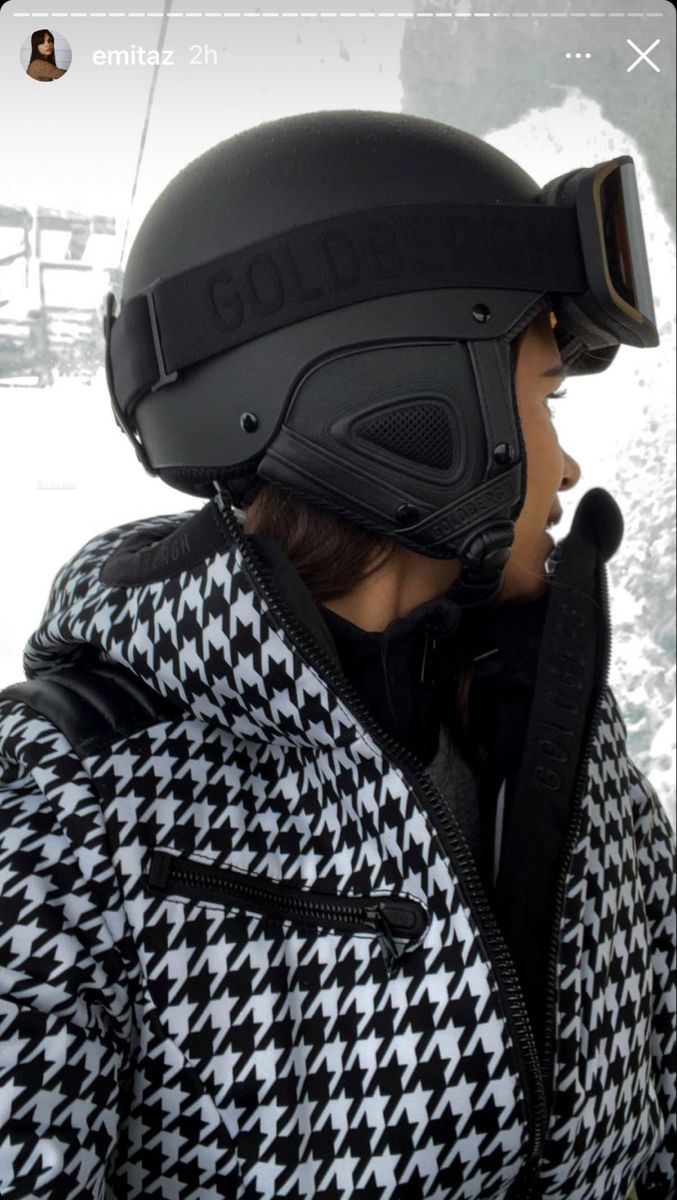 a person wearing a black and white jacket with a helmet on top of their head