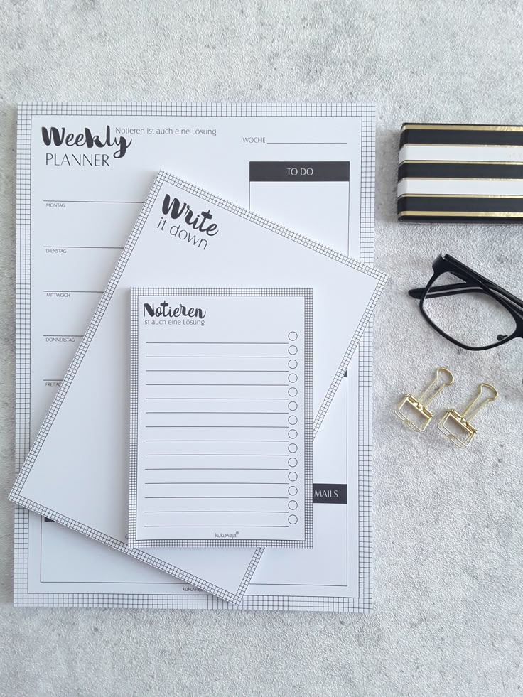 the contents of a planner laid out on top of a table next to glasses and pencils