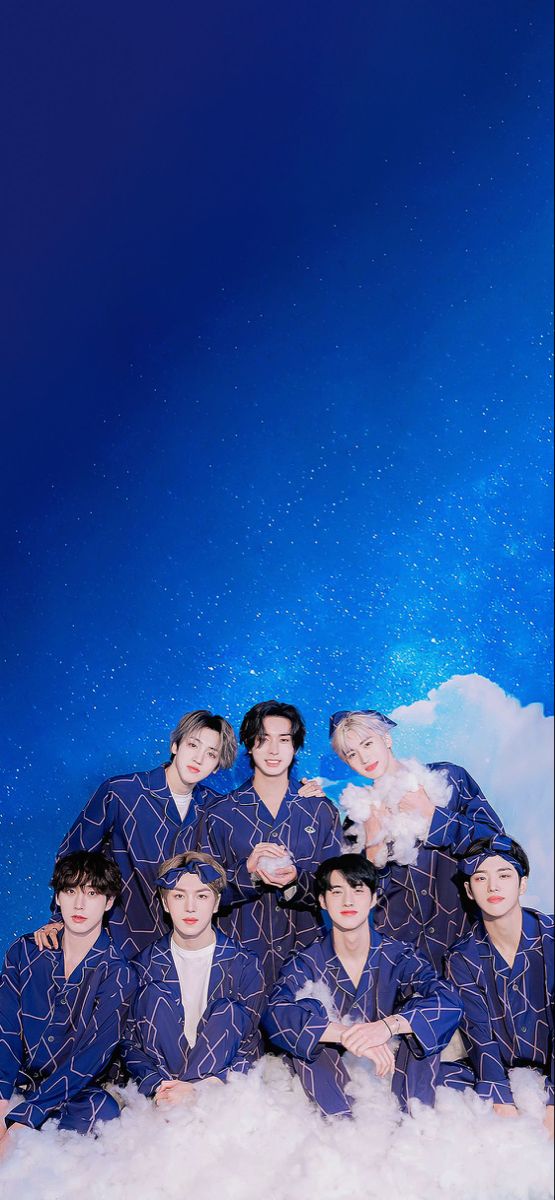 a group of young men sitting on top of a pile of white fluffy clouds in front of a blue sky