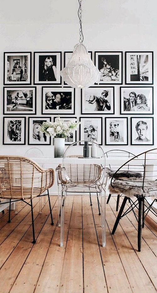 a dining room with pictures on the wall and chairs in front of it that are clear