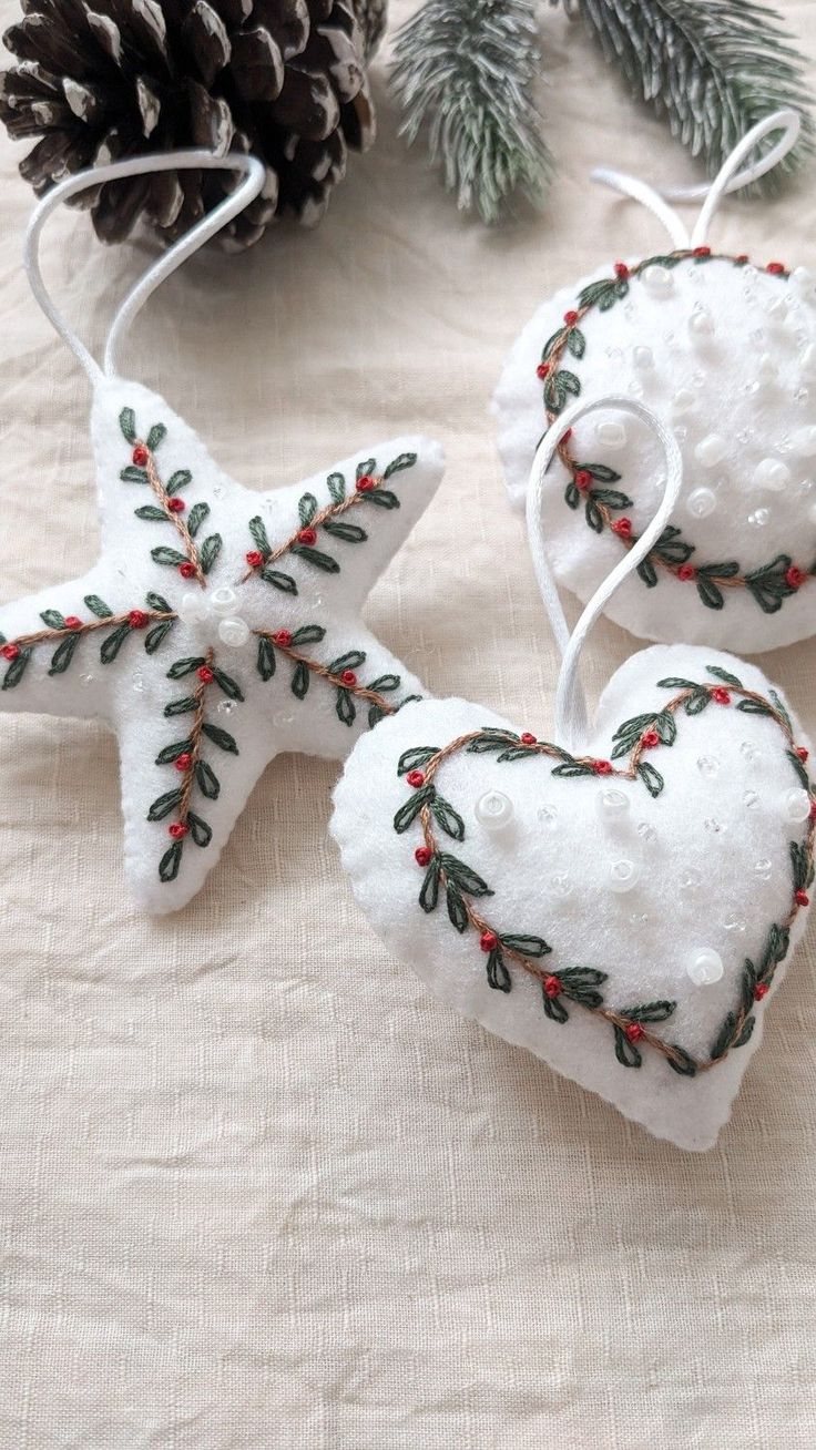 two ornaments made out of snow and pine cones