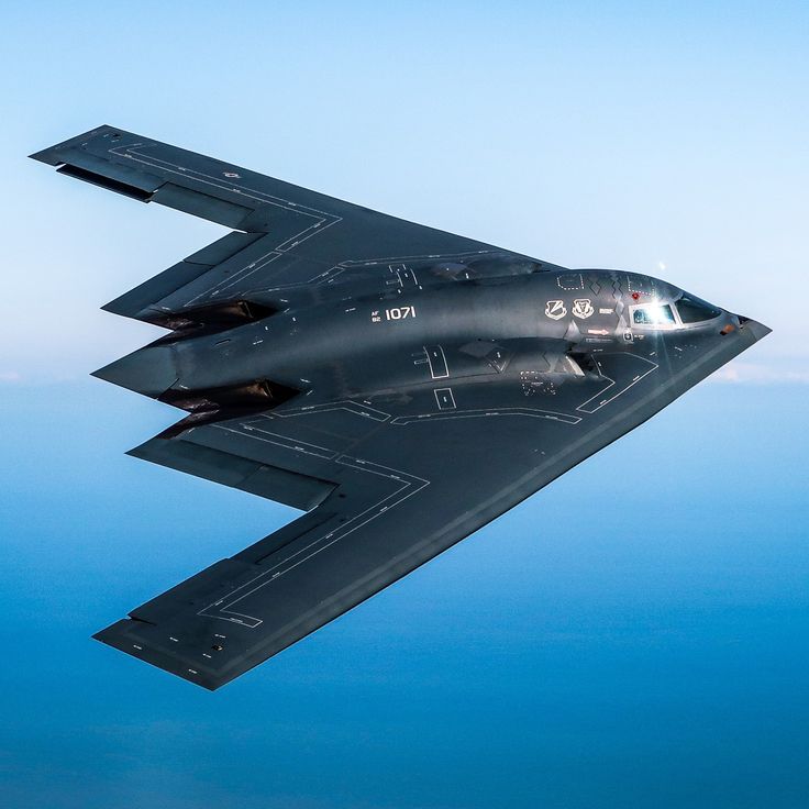 a fighter jet flying through the air with its landing gear down