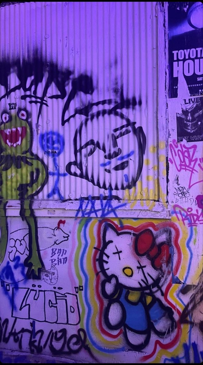 graffiti on the side of a building with an image of a hello kitty and frog