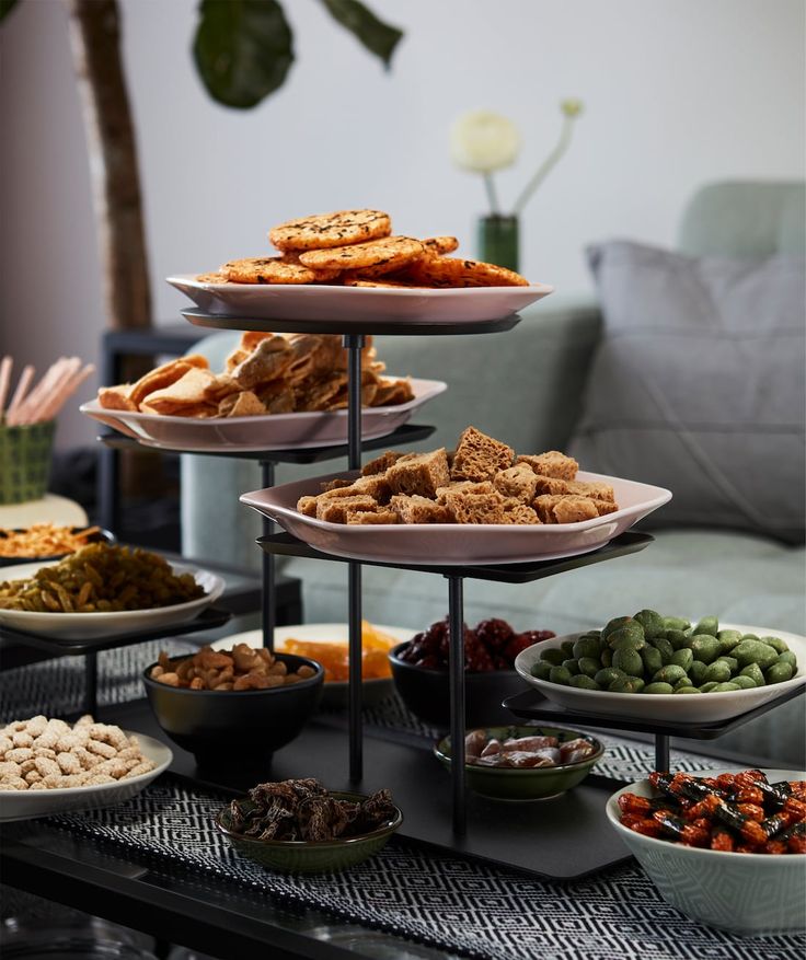 an assortment of food is displayed on a table in front of a couch and potted plant