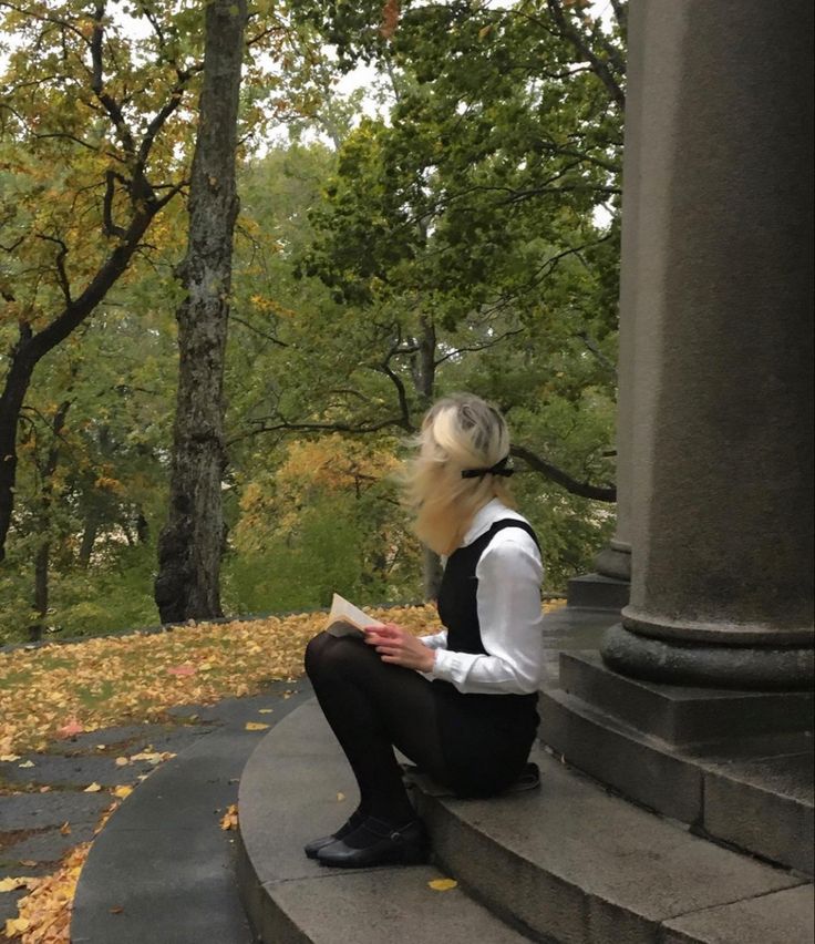 a woman sitting on steps reading a book