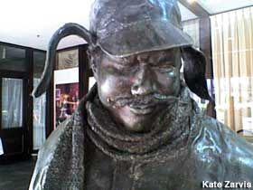 a statue of a man wearing a hat and scarf