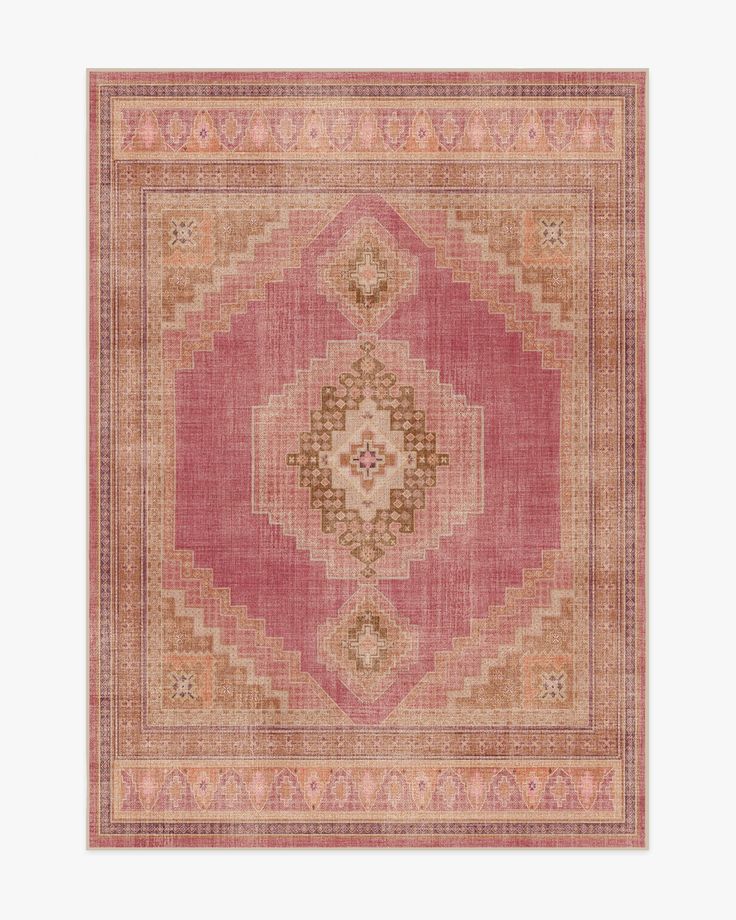 a pink rug with an intricate design on the center and sides, in different colors